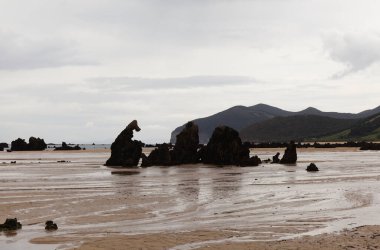 Cantabria, beach Trengandin in Town of Noja, with karst formations revealed by a low tide  clipart