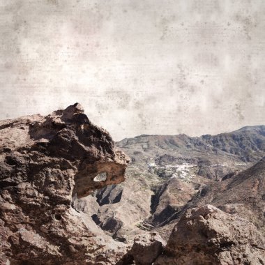 textured stylish old paper background, square, with landscape of Gran Canaria, around the Dog of Bentayga rock formation  clipart