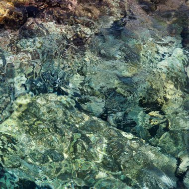 Kayalık zeminin üzerinde saydam okyanus suyu olan soyut bir arka plan