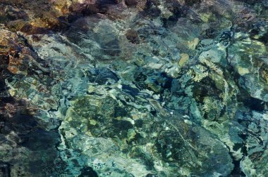 Kayalık zeminin üzerinde saydam okyanus suyu olan soyut bir arka plan