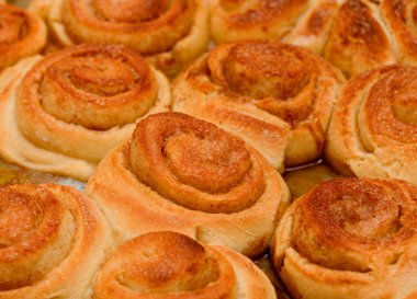 Yeni yapılmış tarçınlı çörek tepsisi, makro gıda arka planı.