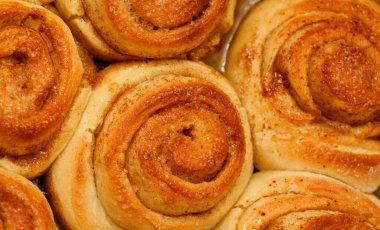 Yeni yapılmış tarçınlı çörek tepsisi, makro gıda arka planı.