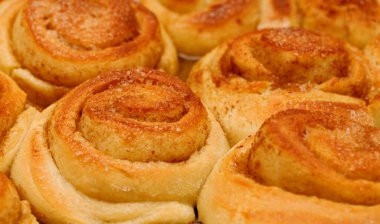 Yeni yapılmış tarçınlı çörek tepsisi, makro gıda arka planı.