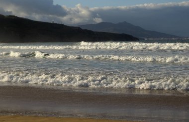 Basque Country, dark sand beach Playa de La Arena  between Biscayan municipalities of Ciervana and Musques clipart