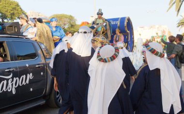 Las Palmas de Gran Canaria, Spain - January 5 2025: Tourists and locals enjoy Cavalcade of Magi, a traditional parade with Three Magi on Epiphany's eve clipart