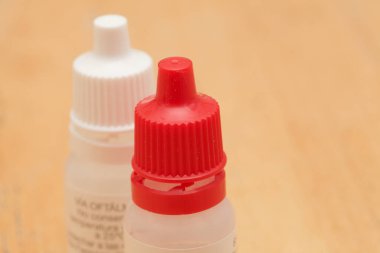 small plastic eyedrop dispenser bottles with different colors of cup clipart