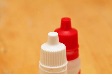 Farklı renkte küçük plastik göz damlası şişeleri.