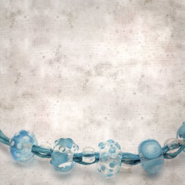 desenli eski kağıt arka plan, kare, mavi ve şeffaf cam boncuklardan oluşan basit bir kolye