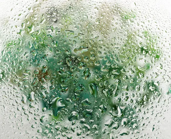 Şeffaf cam yüzeyinde küçük su damlacıkları var.