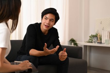 Yakışıklı genç adam kanepede oturuyor ve psikologla görüşüyor. Psikoterapi ve akıl sağlığı konsepti.