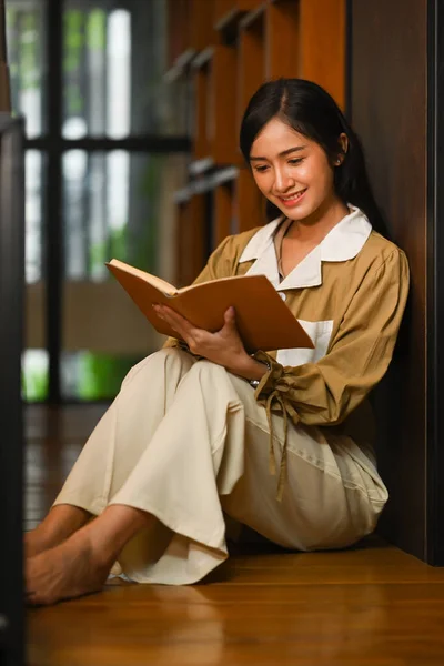 平和的なアジアの女性の肖像大学図書館で床に座って本を読んで — ストック写真