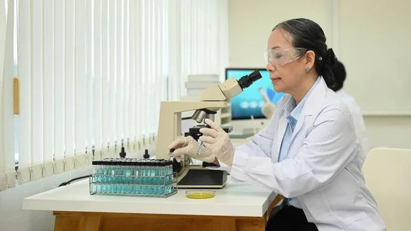 Volwassen Vrouwelijke Biotechnologie Specialist Zoek Onder Microscoop Het Uitvoeren Van — Stockfoto