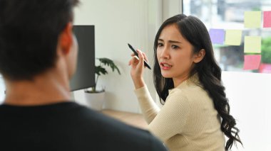 Görevi açıklayan ciddi genç bir kadın ya da iş stratejisini meslektaşıyla tartışan biri..