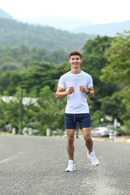 Aktif sporcu sabahları parkta koşuyor. Sağlıklı yaşam tarzı, egzersiz ve sağlık konsepti.