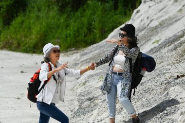 Kayalık duvarların önünde gülümseyen orta yaşlı kadınlar. Holliday, insanlar ve açık hava aktivitesi konsepti.