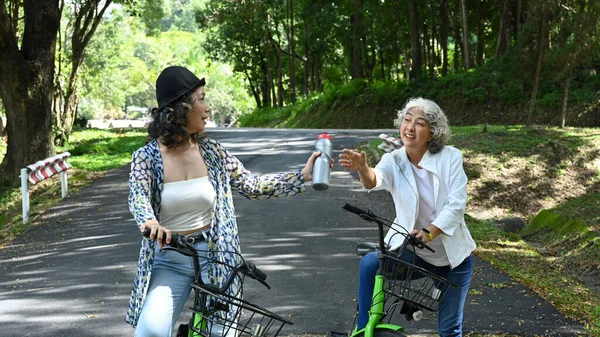 Orta Yaşlı Kadınlar Yaz Parkında Bisiklet Sürerken Şişeden Içip Dinleniyorlar — Stok fotoğraf