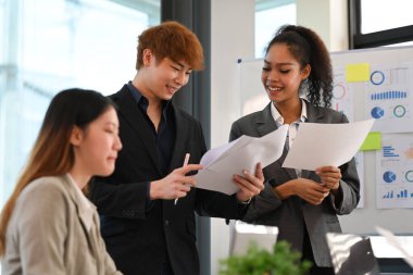 Modern ofiste yeni pazarlama stratejileri üzerine fikir alışverişinde bulunan iş adamları kurun ve tartışın.