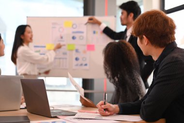 Bir grup yeni iş adamı, şirket ofisindeki proje geliştirme konusunda beyin fırtınası yapıyor, işbirliği yapıyorlar..