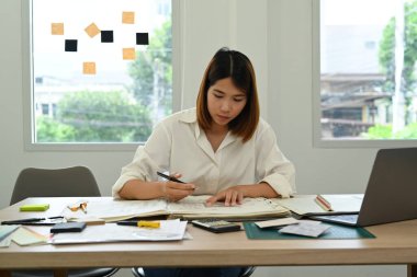 Mimarlar, işyerindeki ahşap masanın planlarını kontrol ediyor..