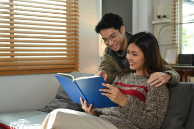 Mutlu genç çift kitap okuyor, kış tatilinde birlikte vakit geçiriyorlar. İnsanlar ve eğlence konsepti.