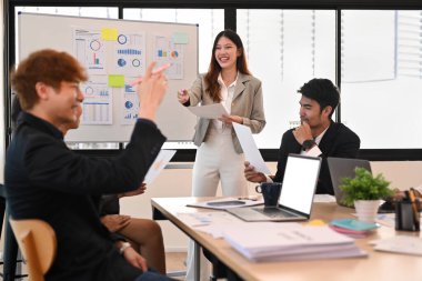 Genç bayan yönetici iş planını açıklıyor, brifingde yeni yönetim stratejisini takıma sunuyor..