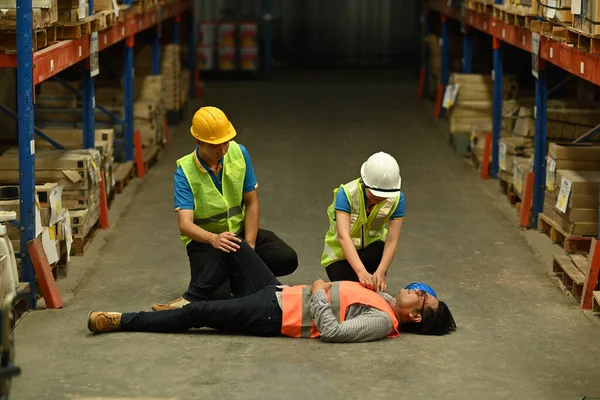Pracovníci Skladu Pomáhají Poskytují Zraněnému První Pomoc Kolegovi Ležícímu Bezvědomí — Stock fotografie