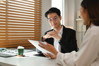 Mutlu genç iş arkadaşları sonuçları analiz ediyor, parlak ofis içi projeleri inceliyor..