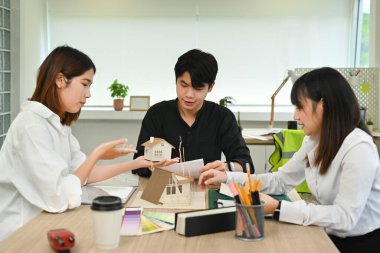 Bir grup genç mimar, yaratıcı ofiste mimari proje üzerinde birlikte çalışıyorlar..