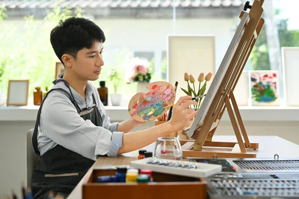 Geconcentreerde Aziatische Mannelijke Kunstenaar Schilderij Met Aquarel Home Studio Kunst — Stockfoto