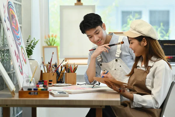 年轻的亚洲男性艺术家和他的女朋友一起在明亮舒适的艺术工作室里画画 休闲活动和艺术概念 — 图库照片