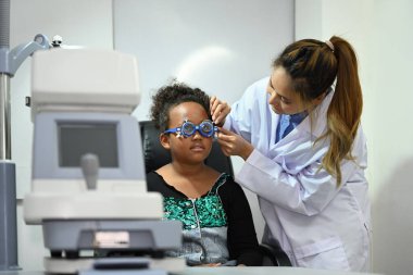 Oftalmolog gözlük ya da klinikte tedavi için kız hastayı muayene ediyor. Sağlık, ilaç, göz görme konsepti.