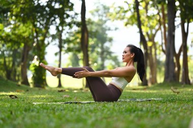 Aktif milenyum kadınlarının yarım tekne ya da Ardha Navasana yoga pozu vermesi. Sağlıklı yaşam tarzı kavramı. 