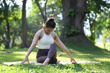 Güneşli tropikal parkta yoga yapan sağlıklı bir Yogi kadının portresi. Meditasyon ve Sağlıklı Yaşam Konsepti.