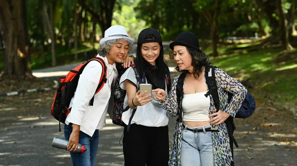 中世の女性や10代の女性が自然公園を歩き スマートフォンのナビゲーターを使用しています テクノロジーと旅行アドベンチャーのコンセプト — ストック写真