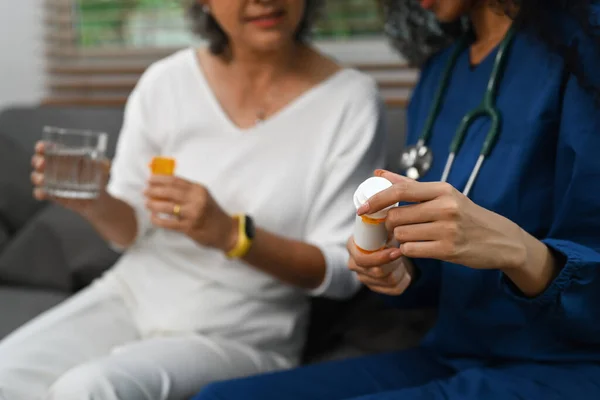 高齢女性への薬の投与量を説明する医療従事者や介護者の作物のイメージ 高齢者医療の概念 — ストック写真