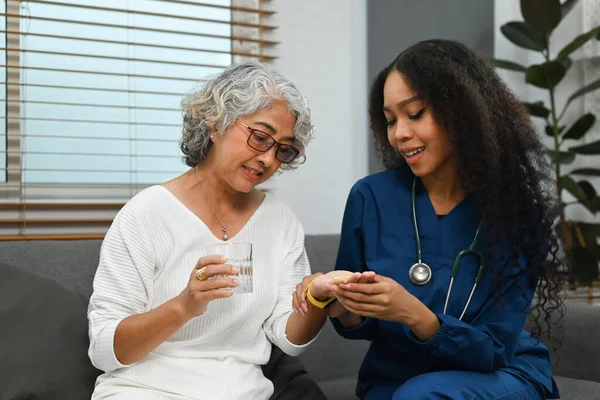 笑顔の女性看護師や介護者は 高齢者に薬の投与量を説明します ヘルスケアの概念 — ストック写真