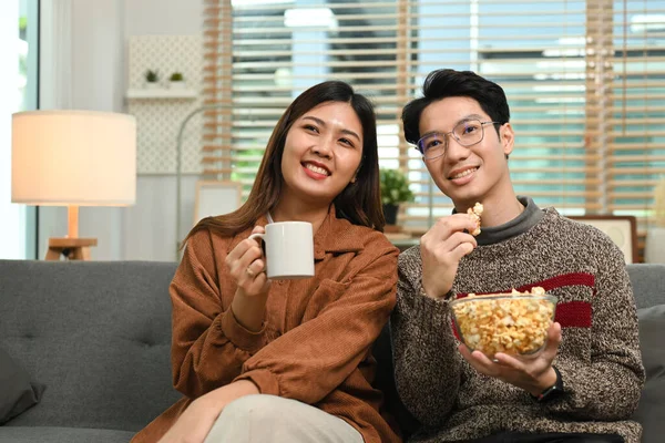 快適な若いカップルはポップコーンを食べ 自宅で好きな映画を見ています レジャー活動のコンセプト — ストック写真