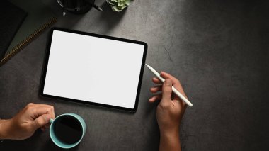 Elleri dijital tablet, boş ekran tableti olan en üst görünüm ofis masası.