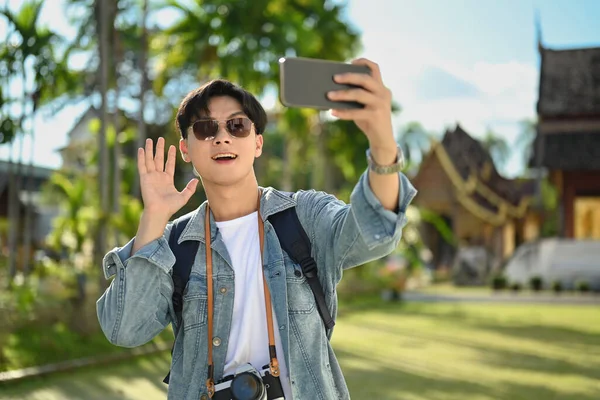 Asyalı Erkek Seyahat Blogcusu Sallıyor Budist Tapınağında Dururken Akıllı Telefonuyla — Stok fotoğraf