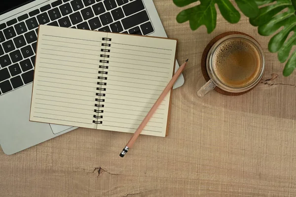 简单的工作空间 木制桌子上有空白笔记本 笔记本电脑 咖啡杯和室内装置 — 图库照片