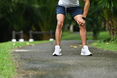 Parkta koştuktan sonra dinlenen yorgun sporcunun görüntüsü. Sağlıklı yaşam tarzı, egzersiz ve sağlık konsepti.