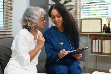 Doktor ev ziyareti sırasında yaşlı kadına tıbbi sonuçları açıklıyor. Yaşlı sağlık hizmetleri ve evde sağlık hizmeti kavramı.