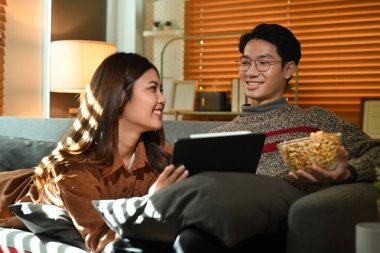 Patlamış mısır yiyip dijital tabletle film izleyen, kış tatillerinde birlikte vakit geçiren sevimli genç bir çift..