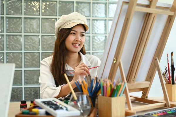 キャンバスの前に座り 水彩で絵を描く女性画家の笑顔 レジャー活動コンセプト — ストック写真