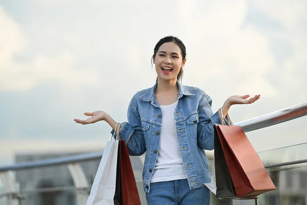 Alışveriş Merkezinin Terasında Elinde Alışveriş Poşetleri Taşıyan Neşeli Asyalı Kadın — Stok fotoğraf