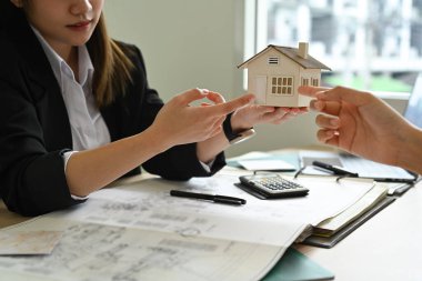 Mimarlık ekibi modern ofiste toplantı sırasında bir inşaat projesini tartışıyor, inceliyor..