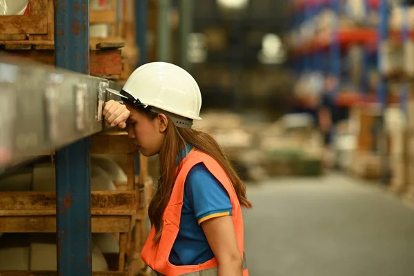 Mujer Cansada Trabajadora Almacén Hardhat Chaqueta Apoyada Estante Metálico Mientras — Foto de Stock