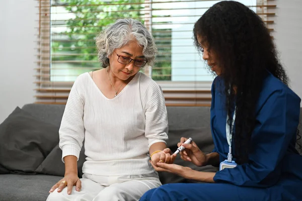 糖尿病高齢女性の血糖値を測定する女性介護者 糖尿病医療の概念 — ストック写真