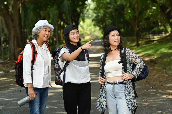 幸せな先輩女性とアジアの女の子がお互いに話をし 春の時間で公園を歩く — ストック写真