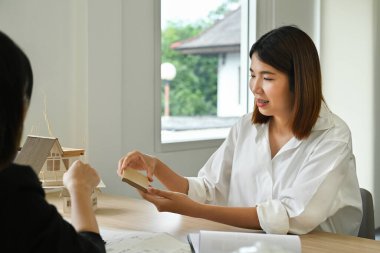 Mühendislerden oluşan bir ekip mimari proje üzerinde birlikte çalışıyor ve inşaat malzemelerini gözden geçiriyorlar..